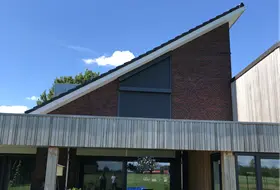 Moderne woning met zwarte rolluiken en schuine dakconstructie