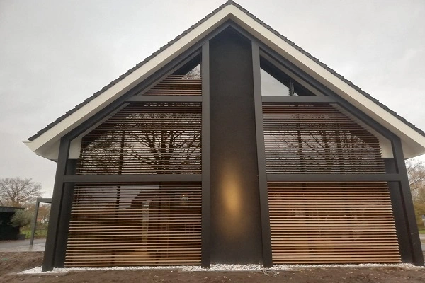Designwoning met een puntgevel en houten zonwering in lamellenstijl Designwoning met een puntgevel en houten zonwering in lamellenstijl
