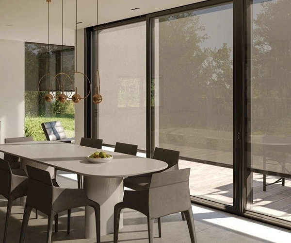 Eetkamer met grote ramen en grijze zonwerende doeken Eetkamer met grote ramen en grijze zonwerende doeken