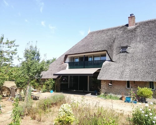 Landelijk huis met rieten dak en een scherm met groene tuin Landelijk huis met rieten dak en een scherm met groene tuin