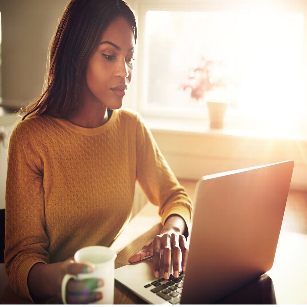 Vrouw die haar zonwering met een laptop bedient Vrouw die haar zonwering met een laptop bedient