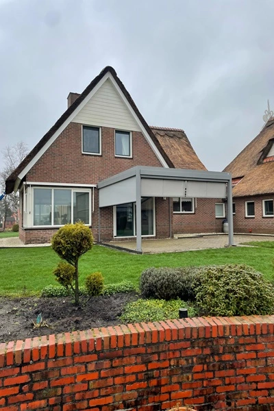 Woning met aangebouwde grijze terrasoverkapping Woning met aangebouwde grijze terrasoverkapping