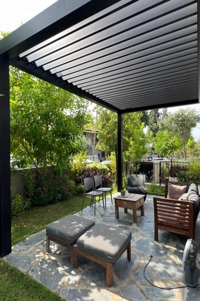 Lamellen overkapping Seesky Bio met tuinmeubels op een stenen terras Lamellen overkapping Seesky Bio met tuinmeubels op een stenen terras