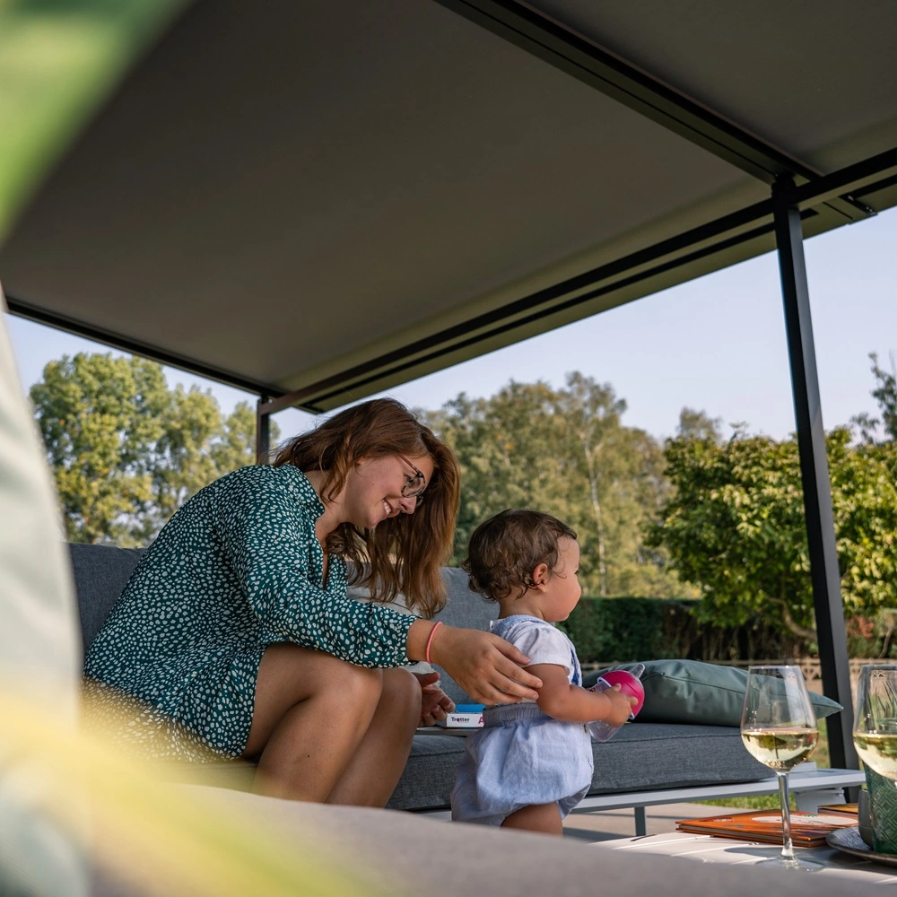 Moeder en kind onder Versuz overkapping met doek in een tuin
