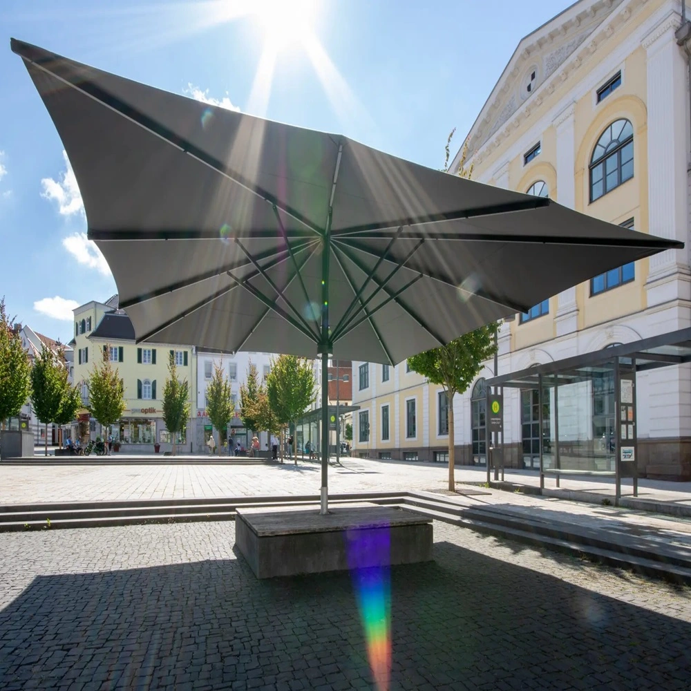Parasol Albatros op een stedelijk plein met zonnestralen die door het doek schijnen