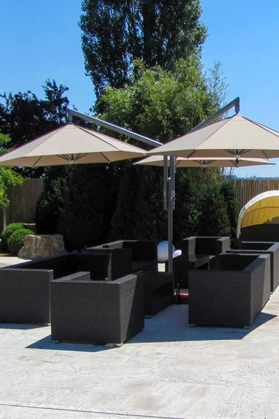 Parasol Rialto boven loungeset bij een zonnige dag in een tuin Parasol Rialto boven loungeset bij een zonnige dag in een tuin