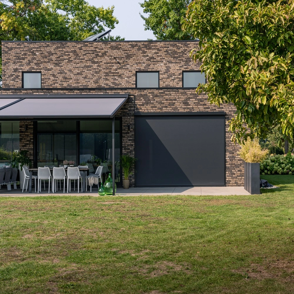 Versuz overkapping met doek in een ruime tuin naast een moderne woning