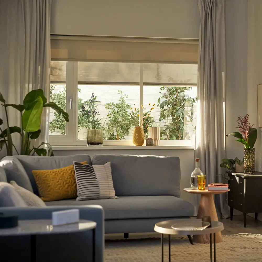 Woonkamer met open gordijn en invallend zonlicht.