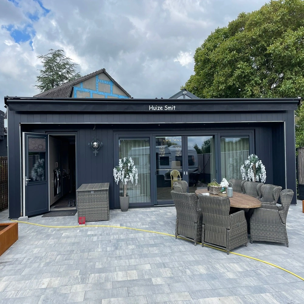Achteraanzicht van terras met Zon en regenscherm Jumbo en tuinmeubilair