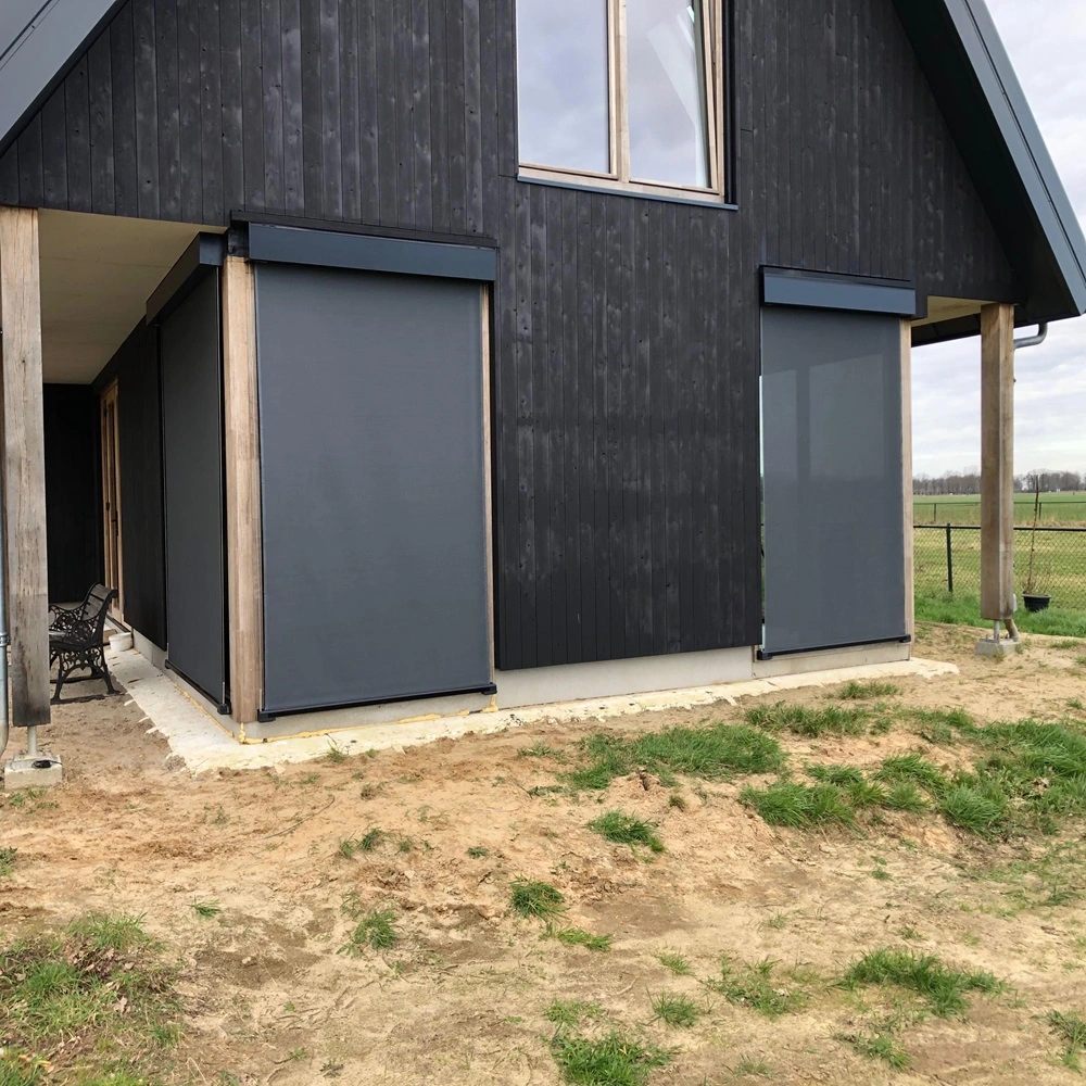 Click Cable screen zonwering op achterzijde van zwarte houten woning