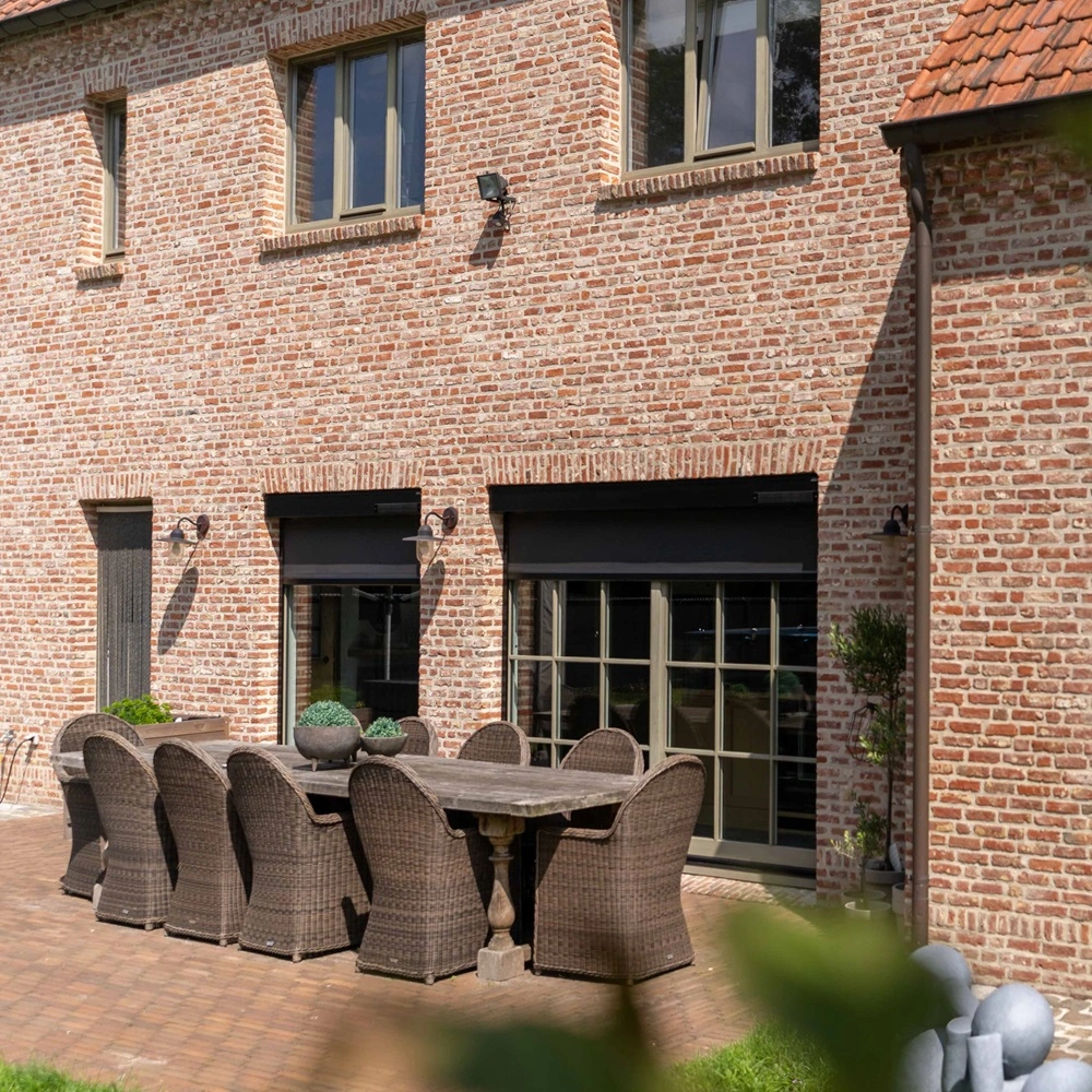 Cool screen Solar zonwering op bakstenen gevel met tuinbeelden op gras