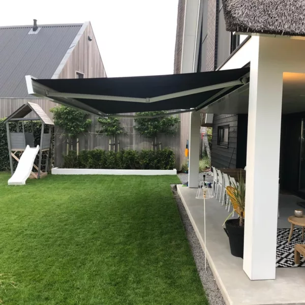 Kubata zonnescherm boven terras met houten meubels en groen gazon in achtertuin Kubata zonnescherm boven terras met houten meubels en groen gazon in achtertuin