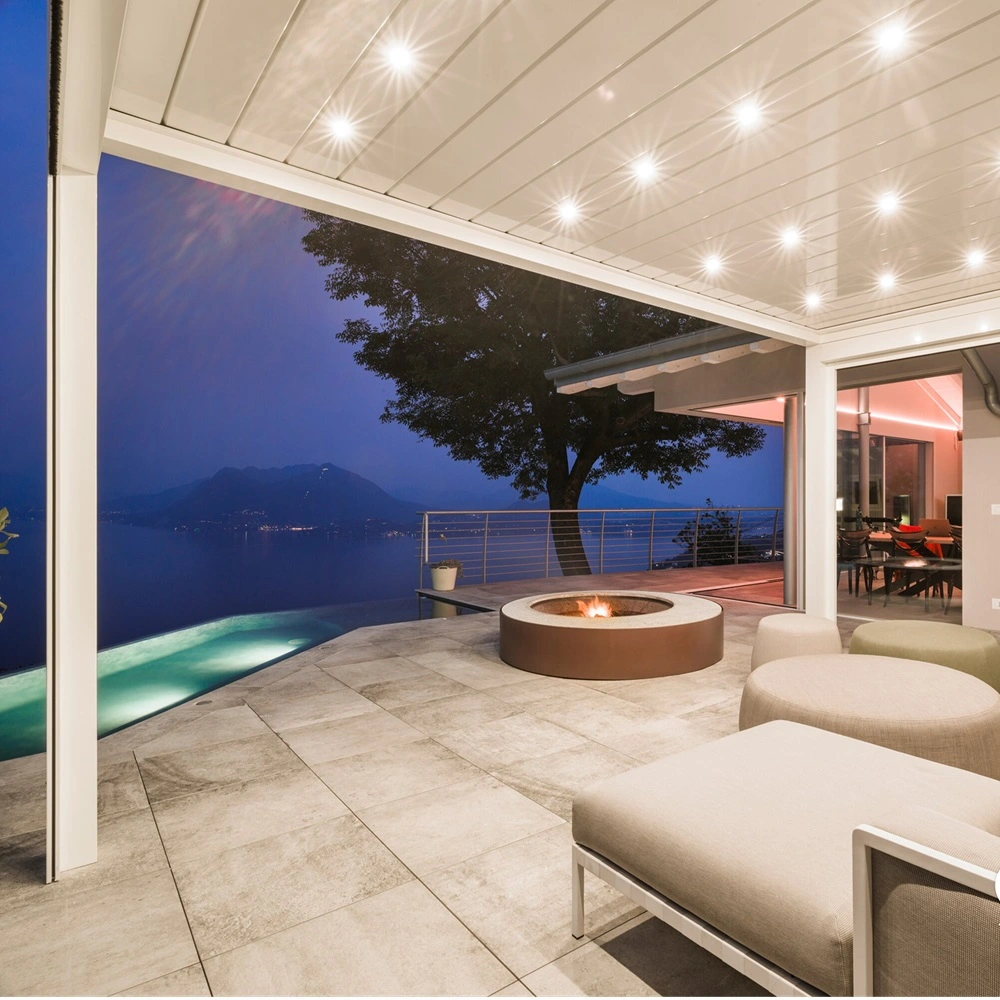 Led spots in overkapping met uitzicht op zwembad en meer bij avondschemering