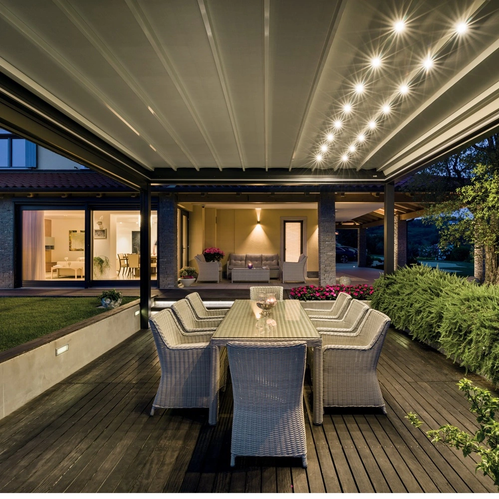 Led spots in vouwdak terrasoverkapping met eettafel bij sfeervol verlichte woning