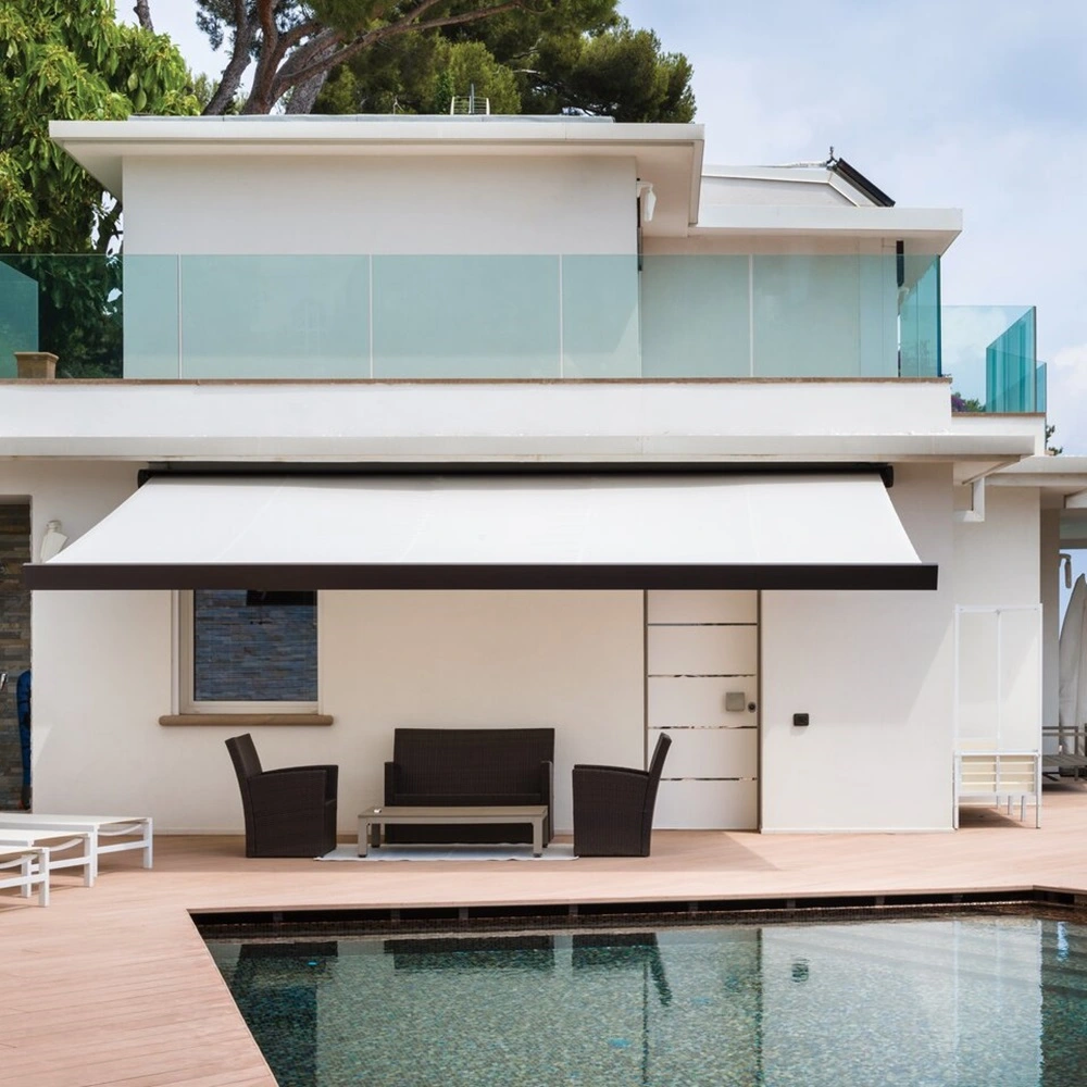 Nodo knikarmscherm over terras bij zwembad en huis met glazen balustrade