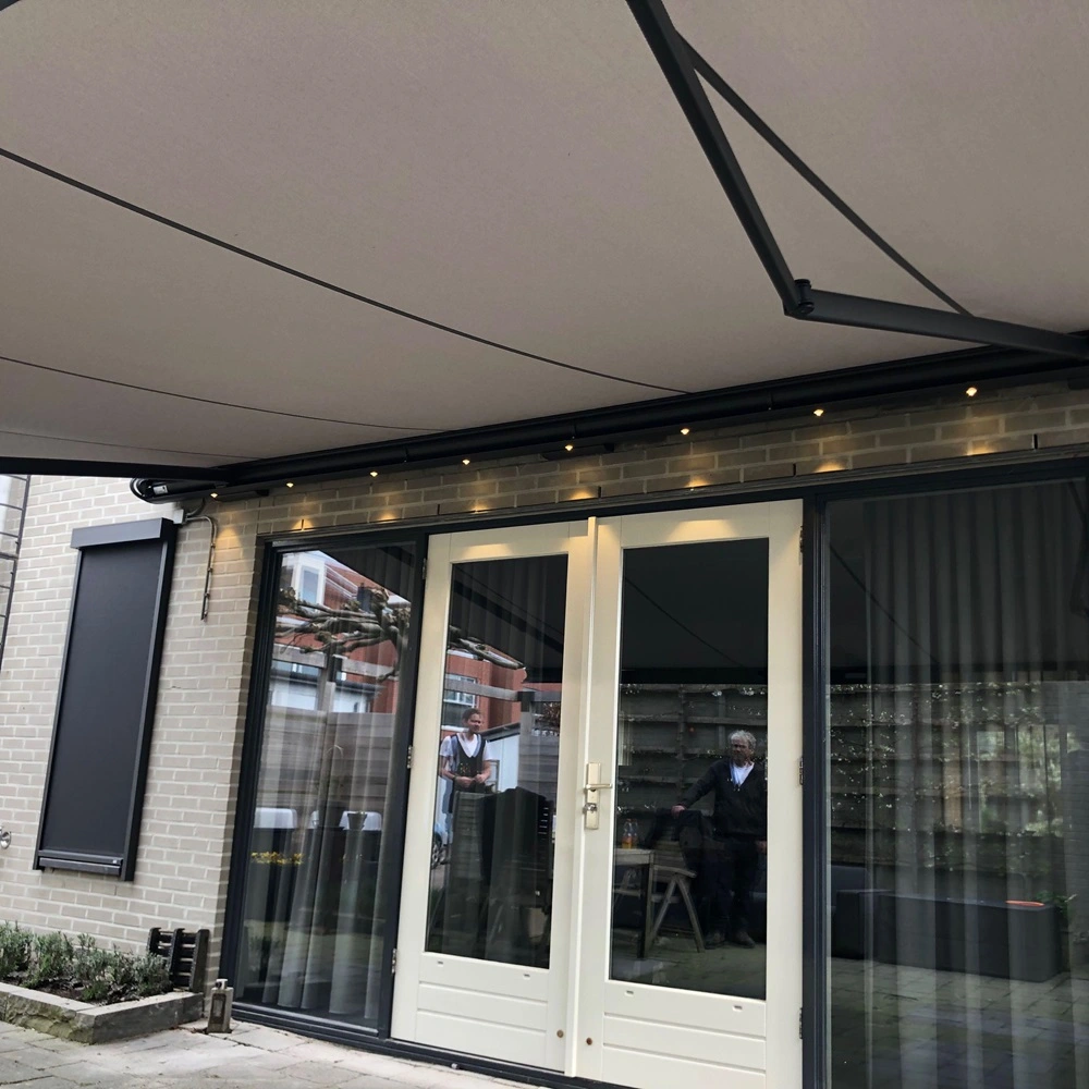 Opal zonnescherm bevestigd aan bakstenen muur boven openslaande deuren naar terras