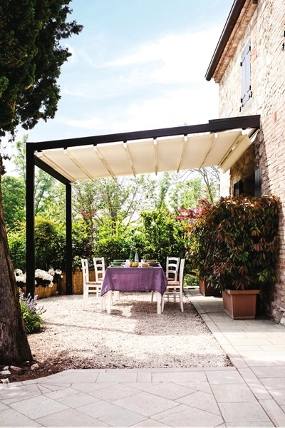 Overkapping Quadro met eetgedeelte in tuin naast stenen huis Overkapping Quadro met eetgedeelte in tuin naast stenen huis