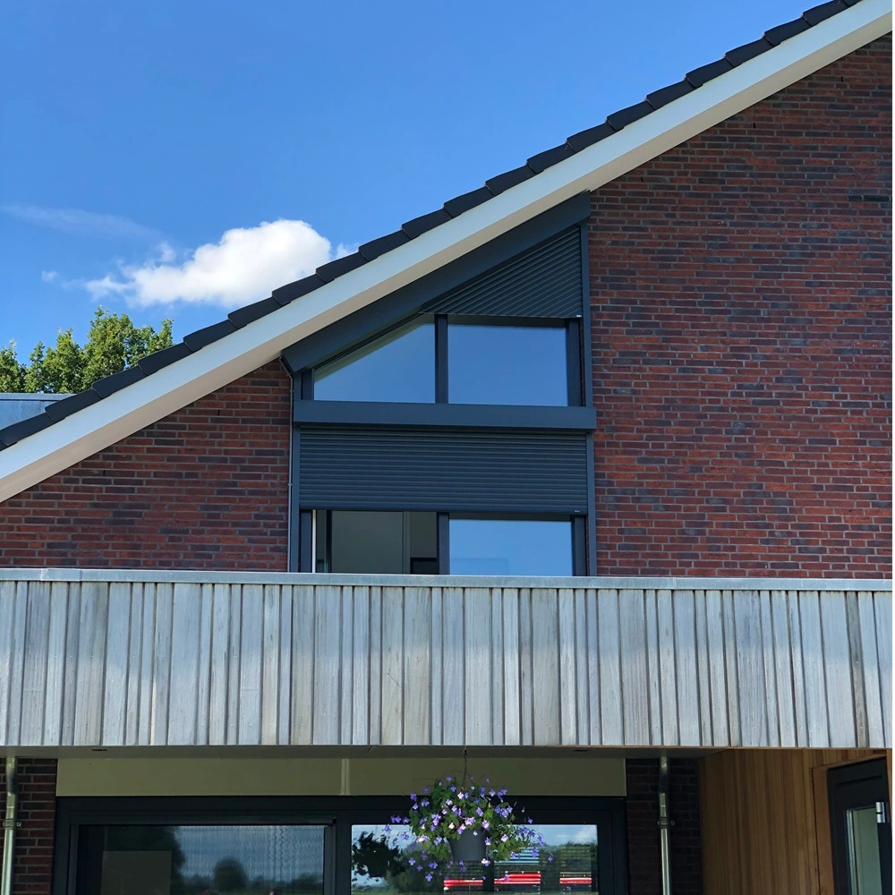 Roma rolluik op een schuine gevel met ramen, naast een houten balkon