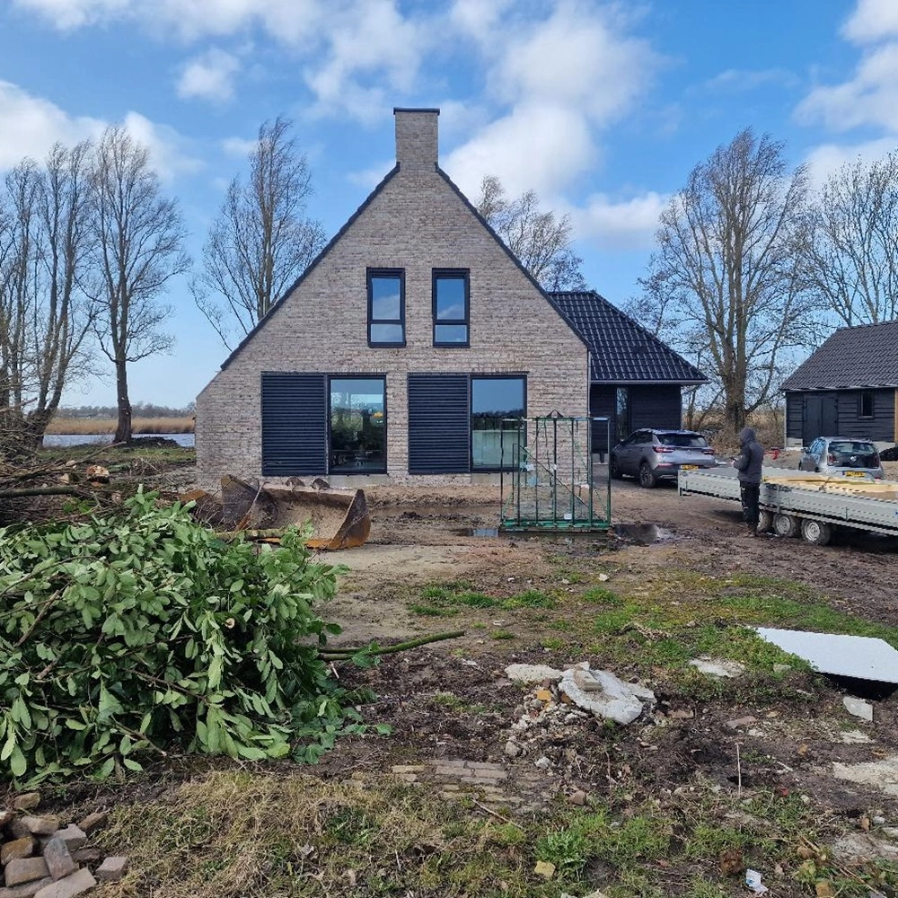 Schuifluiken aan de achterzijde van een huis met een bakstenen gevel