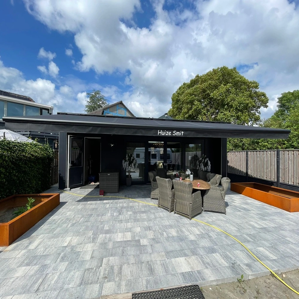 Zon en regenscherm Jumbo bij terras Huize Smit met tuinmeubels en tegelvloer