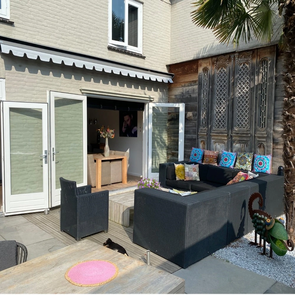 Zon en regenscherm Sunrain boven terras met glazen deuren