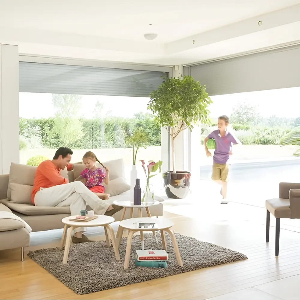 Gezin in woonkamer geniet van binnenkomst van zonlicht door grote ramen