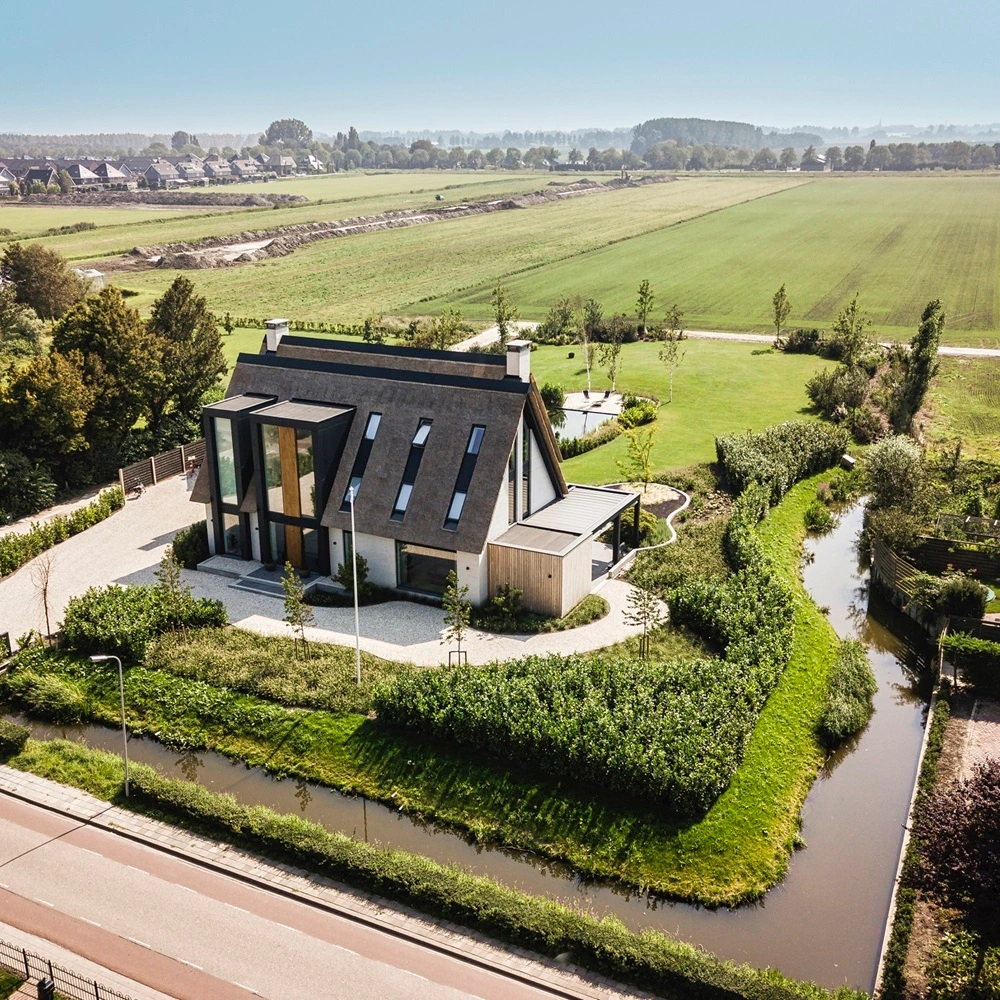 Luchtfoto van villa met Zenit tuinkamer en uitgestrekt landelijk landschap