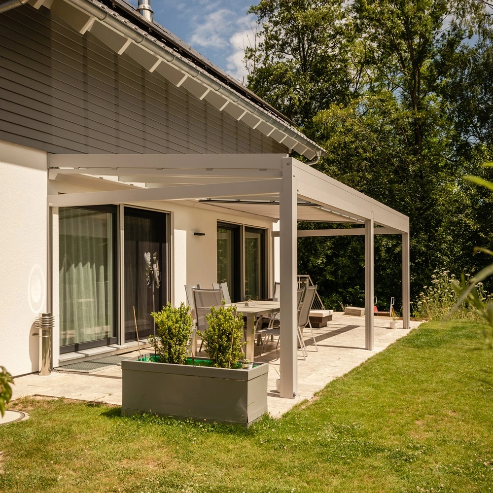 Terras met glazen tuinkamer Nyon in een groene tuinomgeving