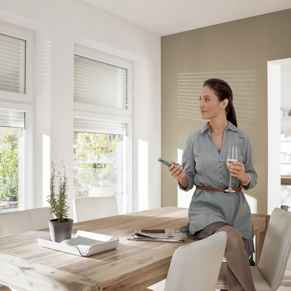 Vrouw bedient de rolluiken met elektrische afstandsbediening