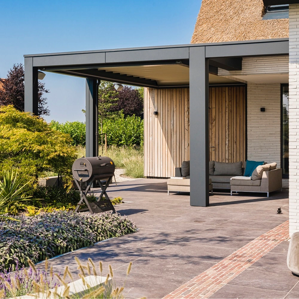 Zenit tuinkamer met schuifdak naast een tuin met kleurrijke beplanting en barbecue