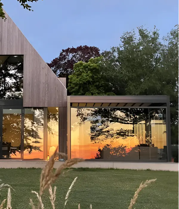 Aanbouw tuinkamer met glazenwanden en schuifdak in samenwerking met architecten