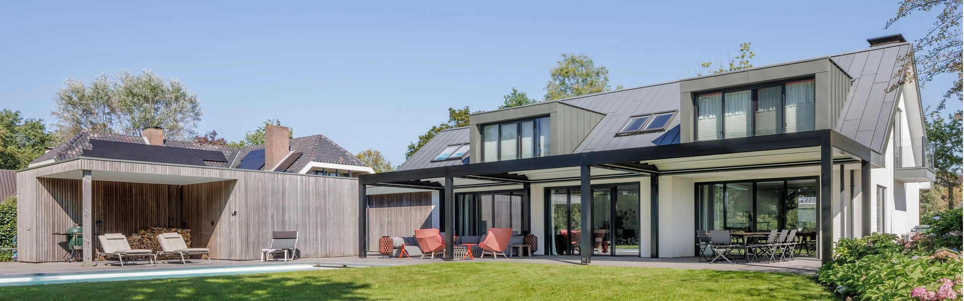 Aluminium overkapping naast zwembad en houten bijgebouw