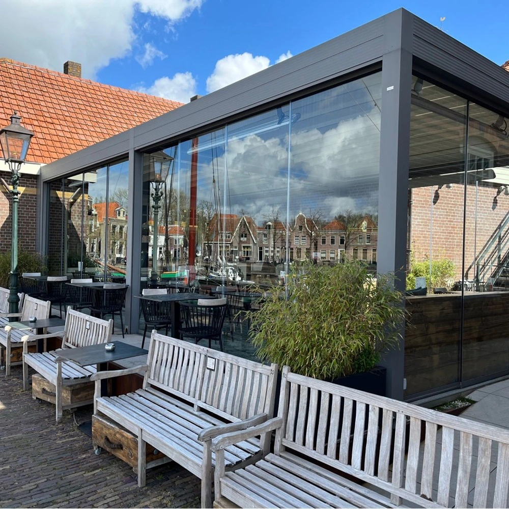 Buitenzijde glazen overkapping bij horecagelegenheid aan het water