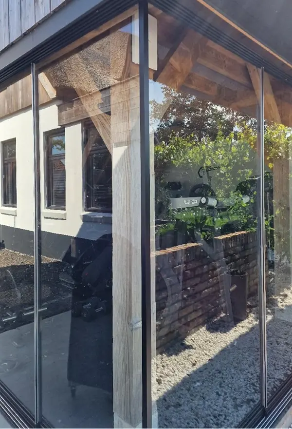 Detail van glazen schuifwand in landelijke buitenruimte