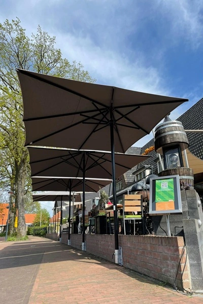 Elegante parasols bieden schaduw op horecaterras Elegante parasols bieden schaduw op horecaterras