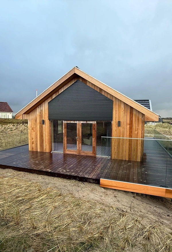 Houten villa met louvre lamellen van Veldman Zonwering op Terschelling