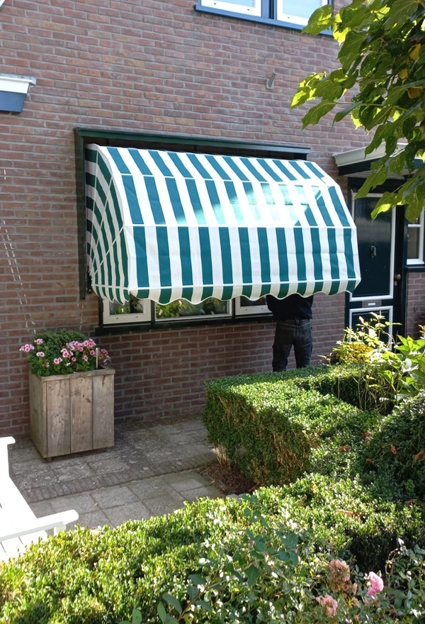 Klassieke markiezen met strepen aan woning in landelijke stijl