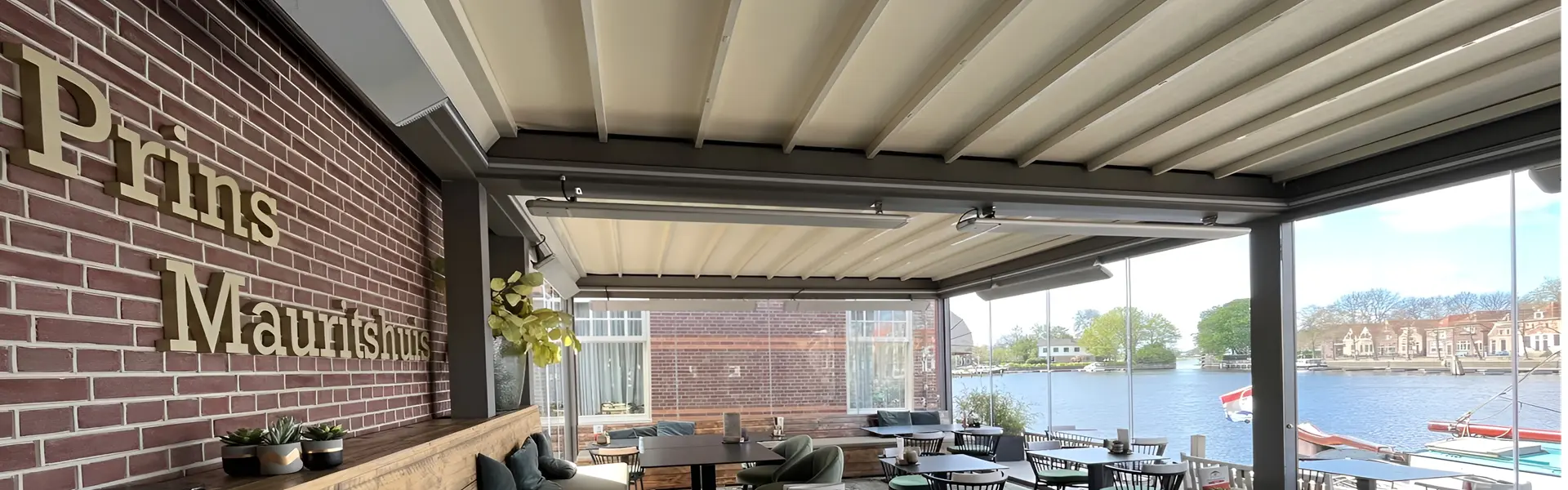 Restaurantoverkapping met glazen wanden en zonwering aan het water