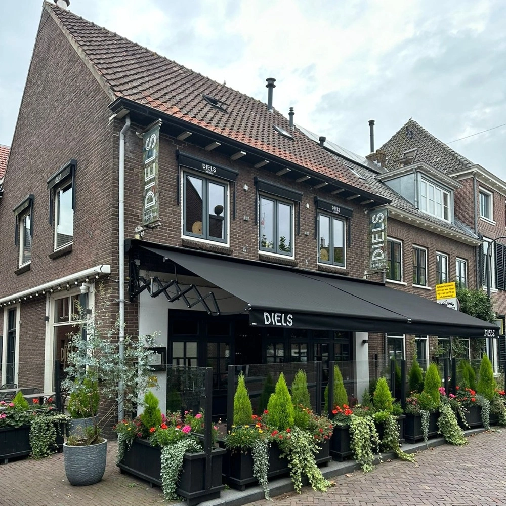 Schaararmscherm mini biedt terrasbescherming bij bloemenzaak Diels