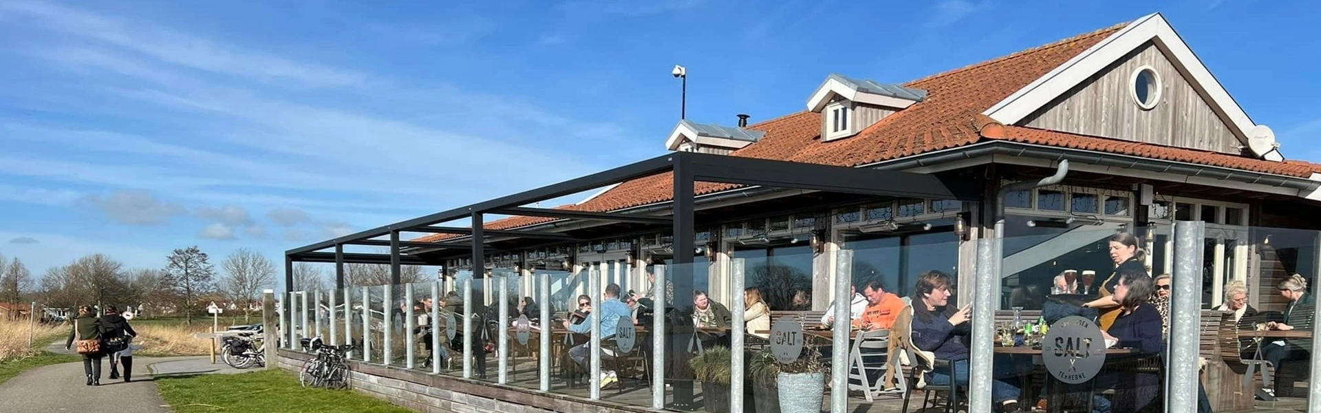 Terrasoverkapping met glazen windschermen bij paviljoen in Terherne