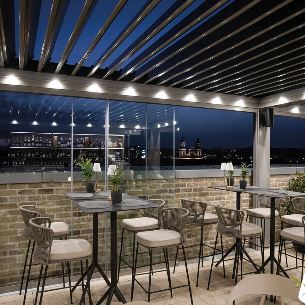 Verlichte lamellenoverkapping bij horecaterras met uitzicht op stad