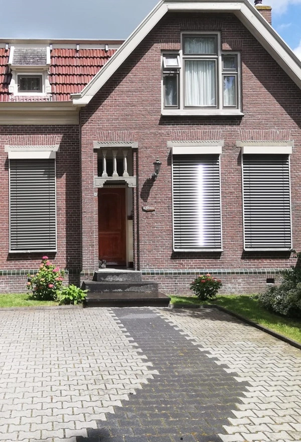 Voorgevel met buitenjaloezieen half geopend voor optimale lichtinval
