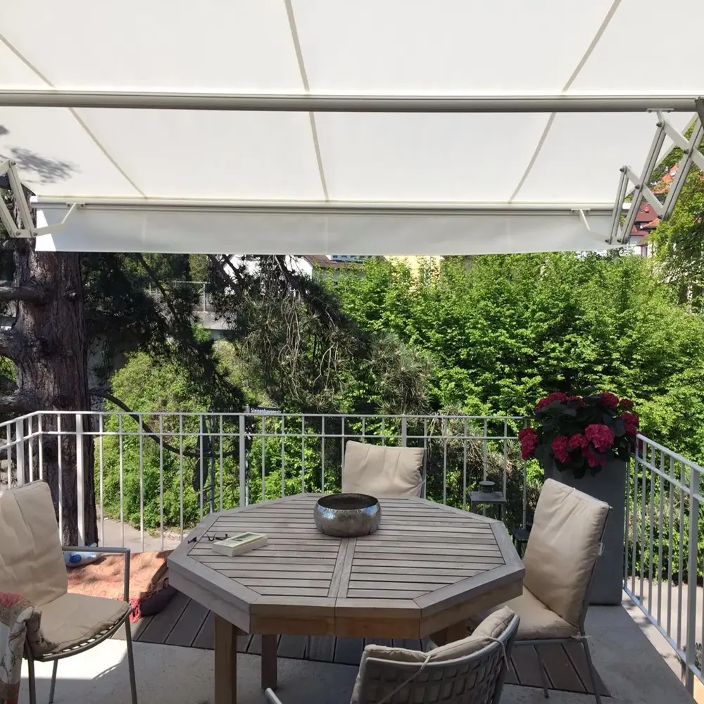 Wit schaararmscherm ZRS boven een balkon biedt schaduw