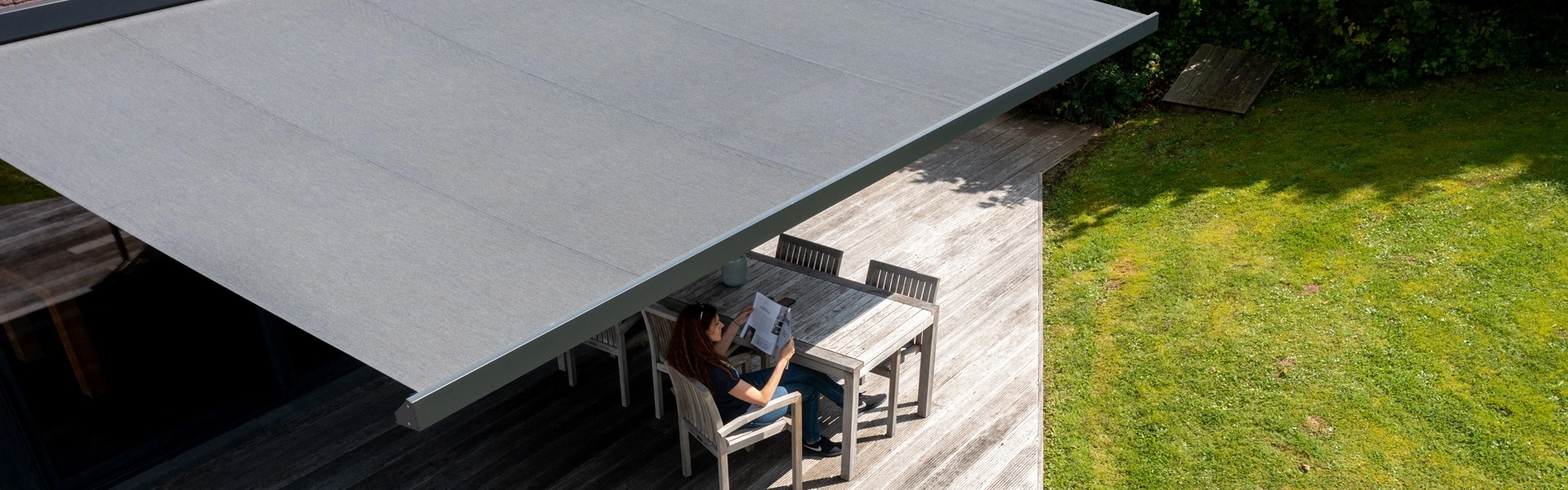 BX270 knikarmscherm boven houten terras in groene tuin