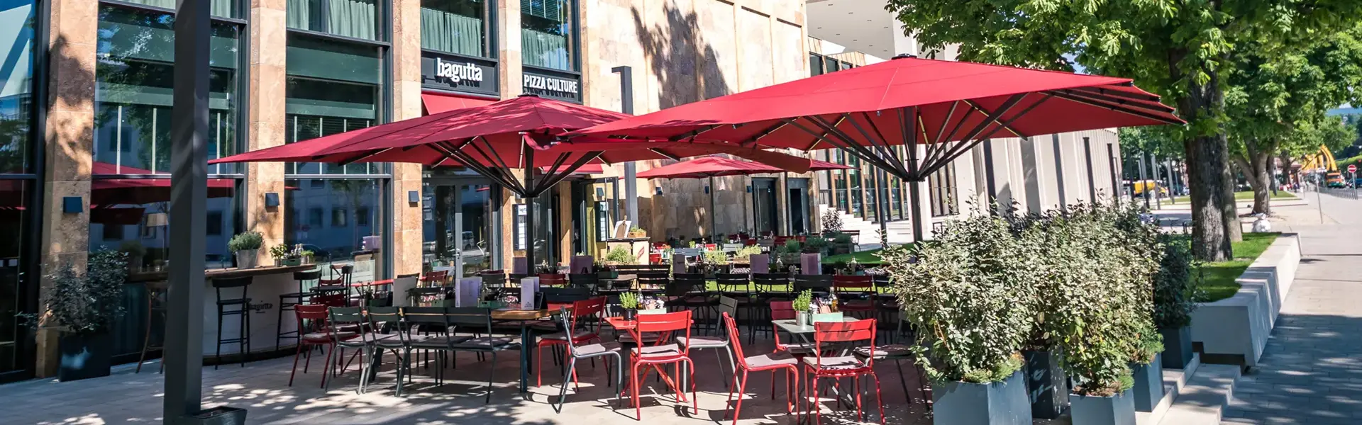 Beige Albatros parasols geplaatst op een hotelterras naast een vijver