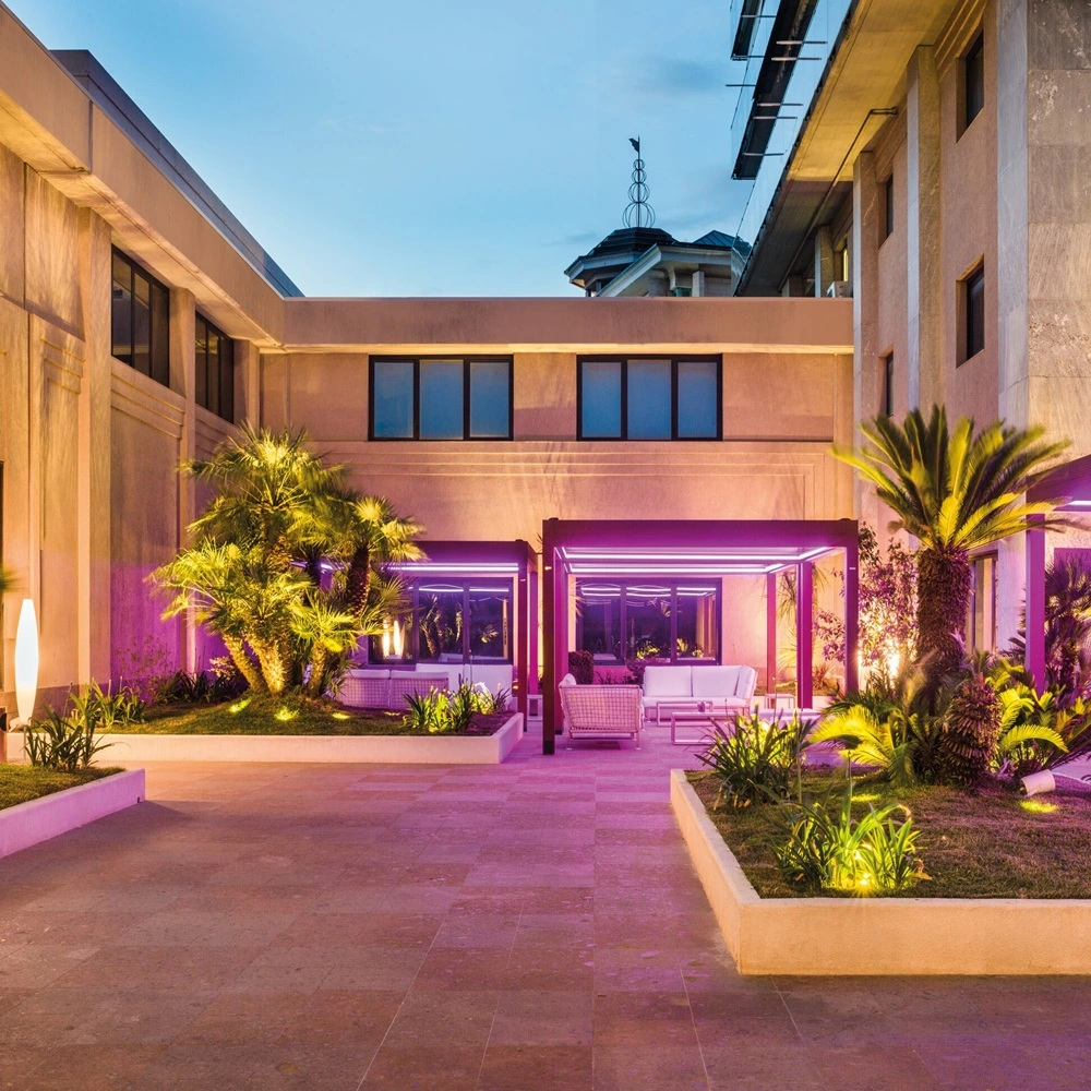 Buitenruimte met ledverlichte pergola, tropische planten en moderne sfeer