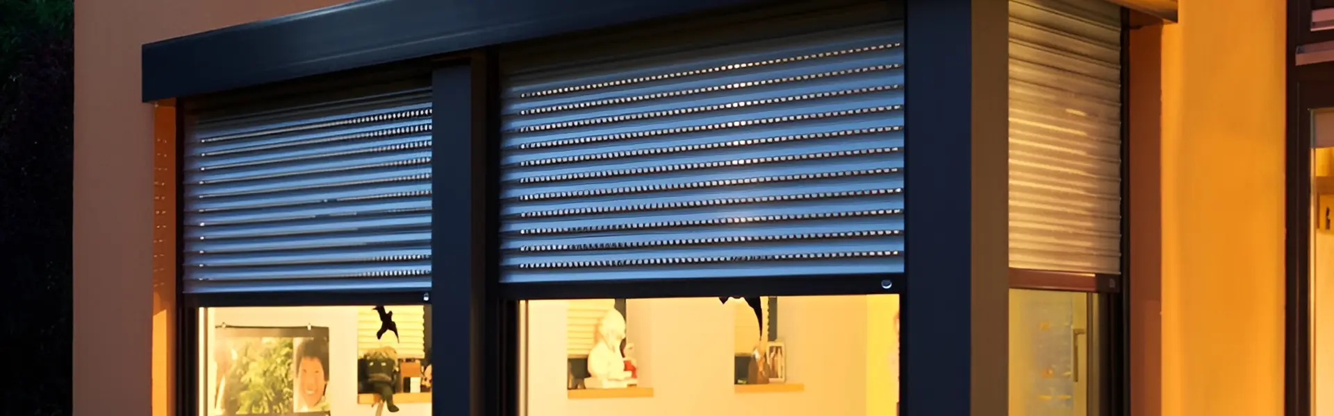 Close-up van Roma rolluik op een feloranje gevel met houten kozijnen