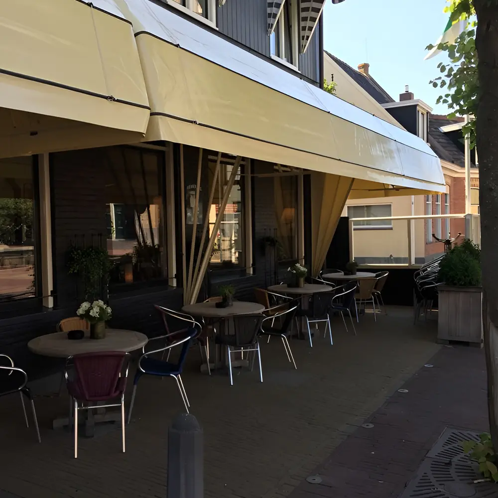 Geel aluminium markies boven terras van horecagelegenheid