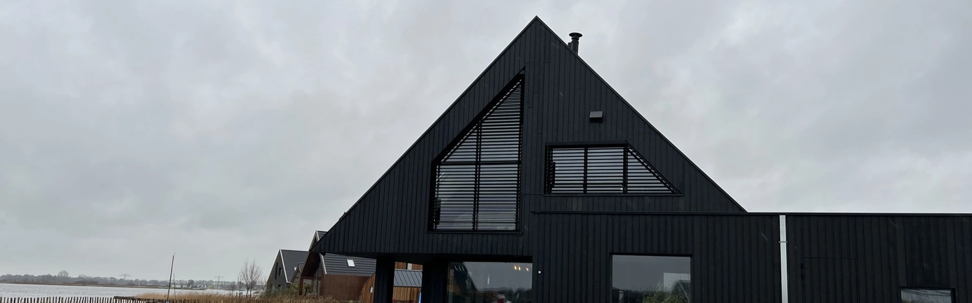 Gevel met zwarte vaste lamellen voor privacy en zonwering