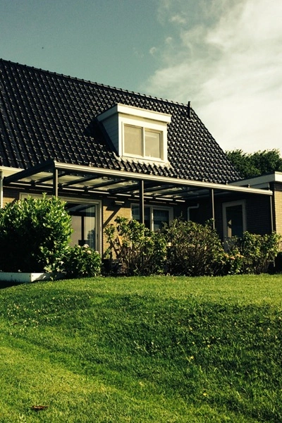 Glazen overkapping Terrazza Sempra aan een vrijstaande woning met tuin Glazen overkapping Terrazza Sempra aan een vrijstaande woning met tuin